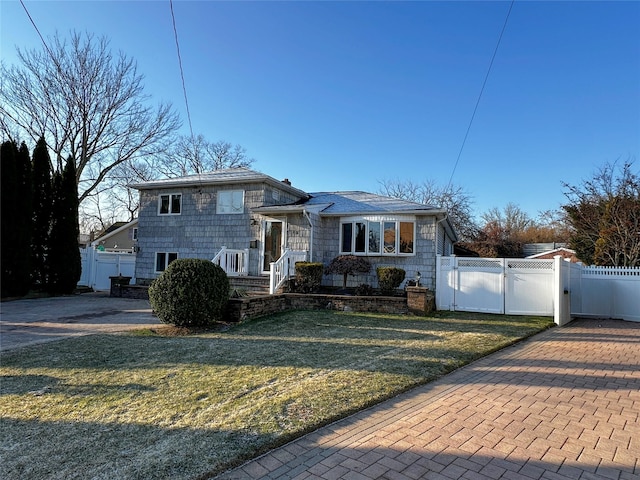 tri-level home with fence, a front yard, and a gate