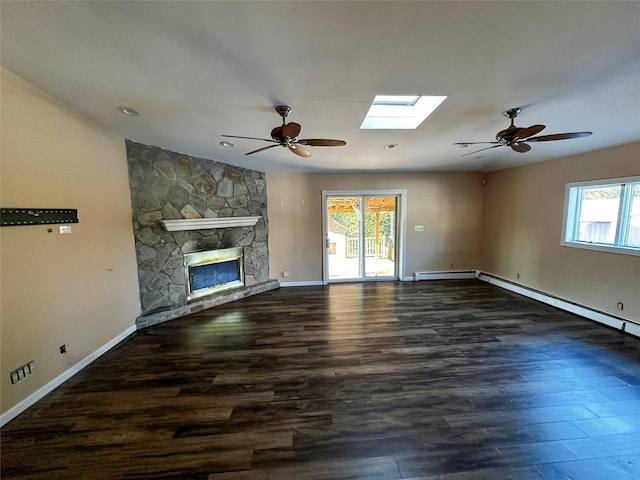 unfurnished living room with baseboard heating, a skylight, ceiling fan, and wood finished floors