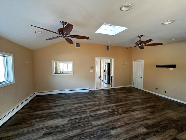 empty room featuring lofted ceiling with skylight, visible vents, ceiling fan, and a baseboard radiator