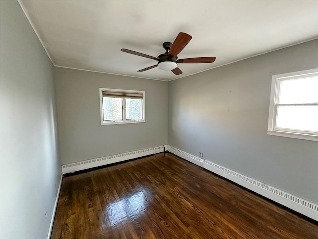 spare room featuring baseboards, dark wood-type flooring, ceiling fan, and a baseboard radiator