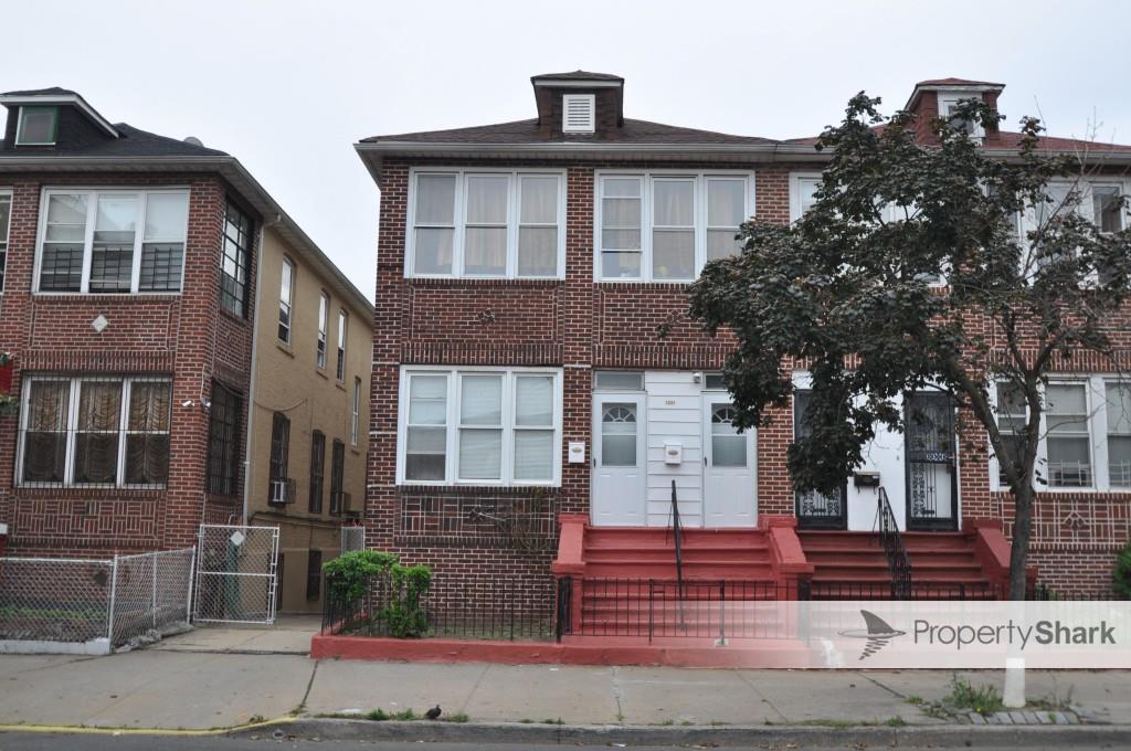 view of front facade with brick siding, entry steps, and fence