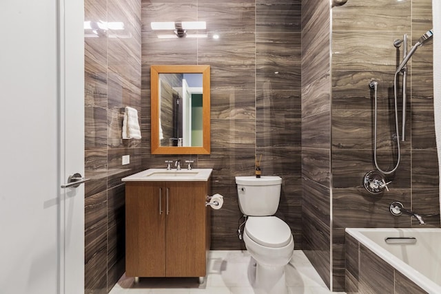 bathroom with tiled shower / bath, toilet, tile walls, and vanity