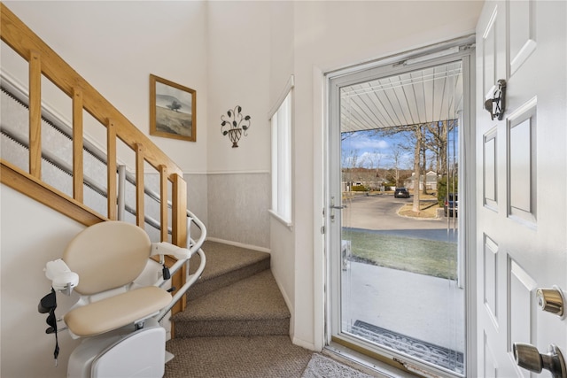 entrance foyer featuring carpet flooring and wainscoting