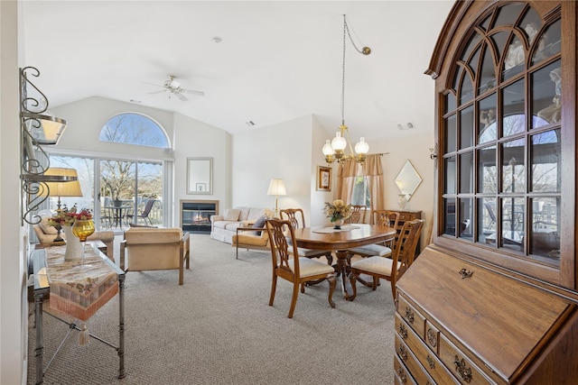 dining room with visible vents, ceiling fan with notable chandelier, high vaulted ceiling, and carpet