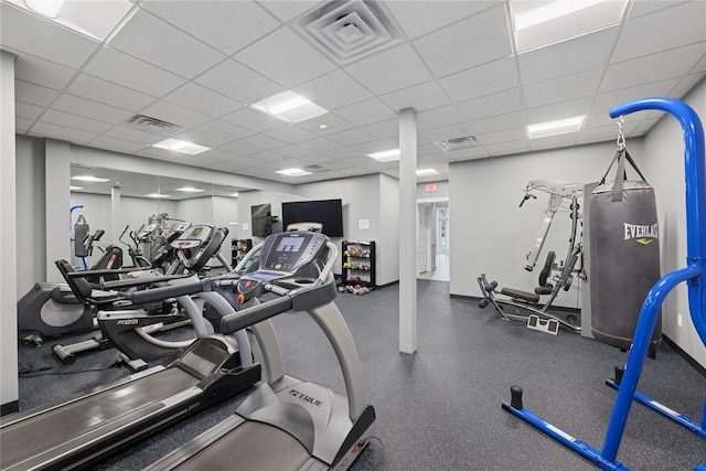 workout area with a paneled ceiling, visible vents, and baseboards