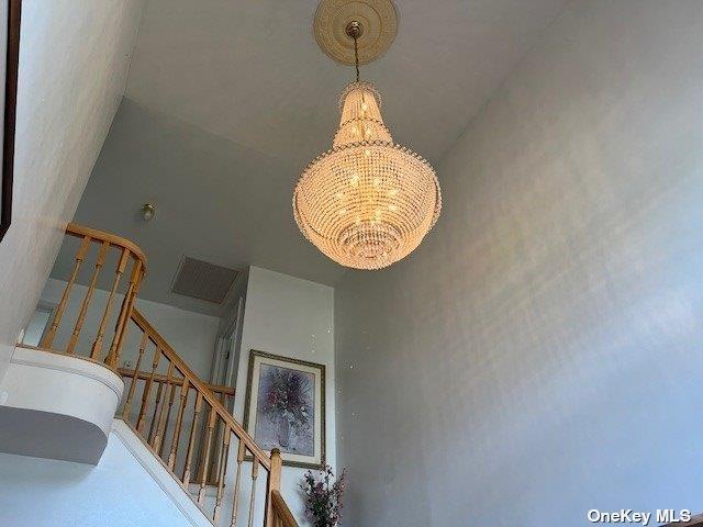 stairway featuring a notable chandelier