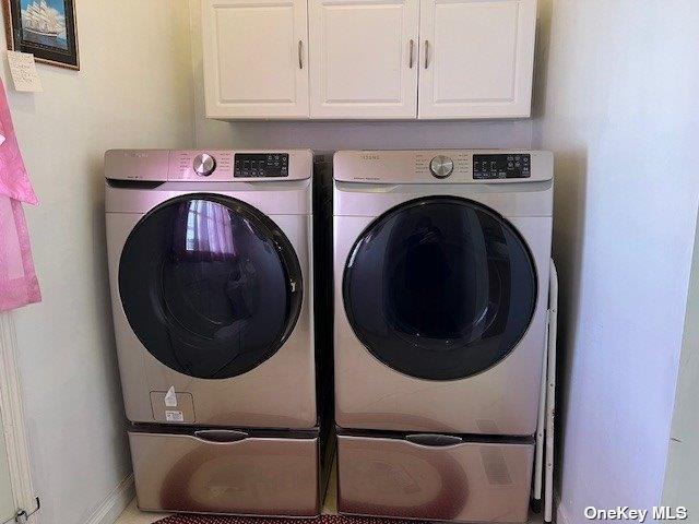 washroom featuring washer and dryer and cabinet space