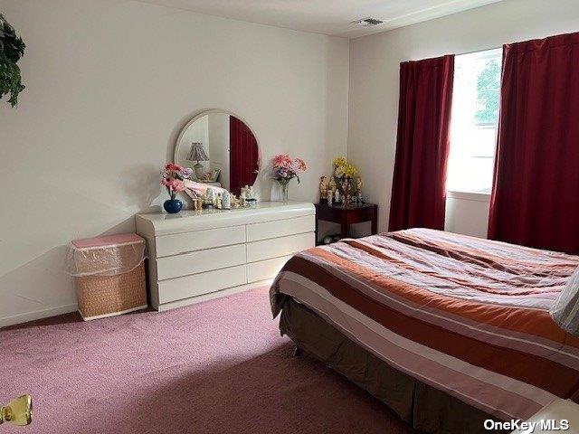 carpeted bedroom featuring visible vents