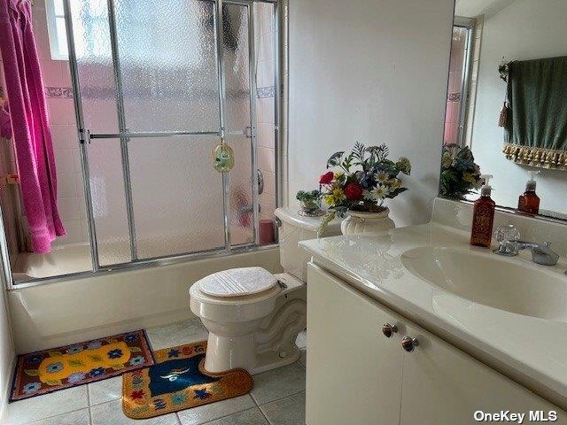 full bath with vanity, toilet, tile patterned flooring, and shower / bath combination with glass door