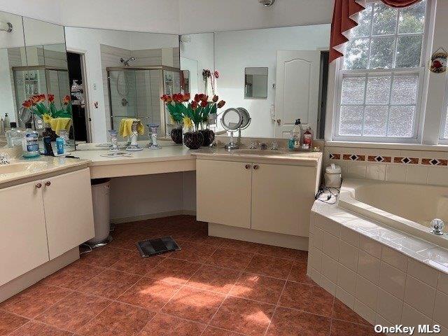 full bath featuring vanity, a stall shower, tile patterned flooring, and a bath