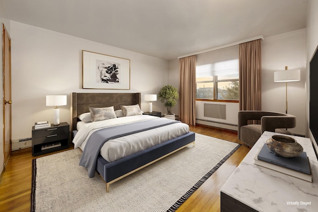 bedroom featuring wood finished floors and baseboard heating