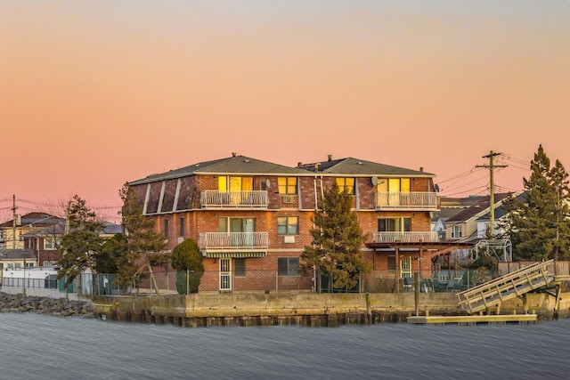 exterior space with brick siding and a water view