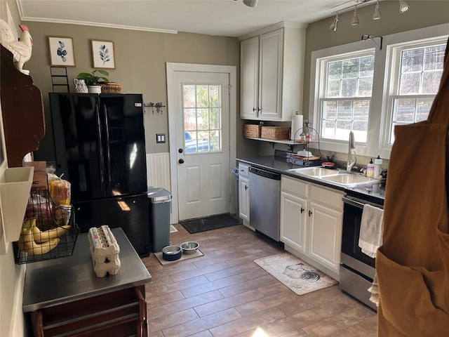 kitchen with white cabinetry, light wood-type flooring, appliances with stainless steel finishes, and a sink