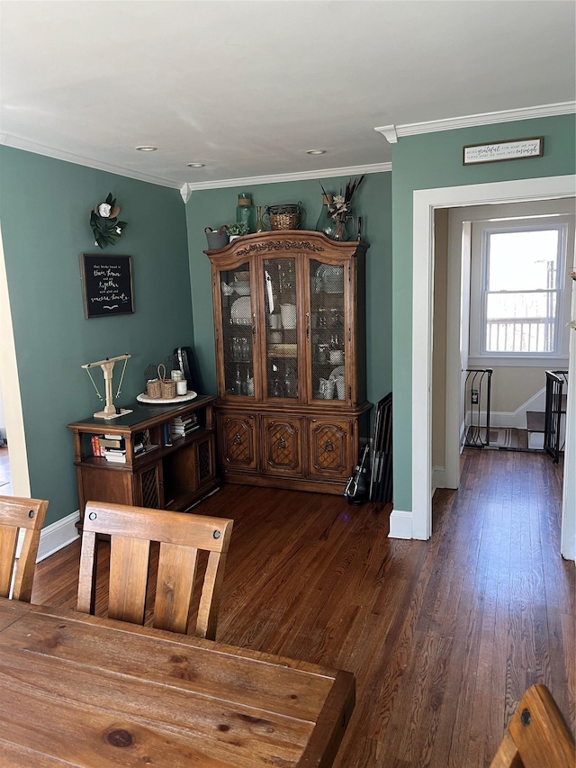 dining space featuring ornamental molding, baseboards, and wood finished floors