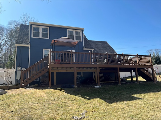 rear view of property with stairway, a lawn, roof with shingles, and a wooden deck