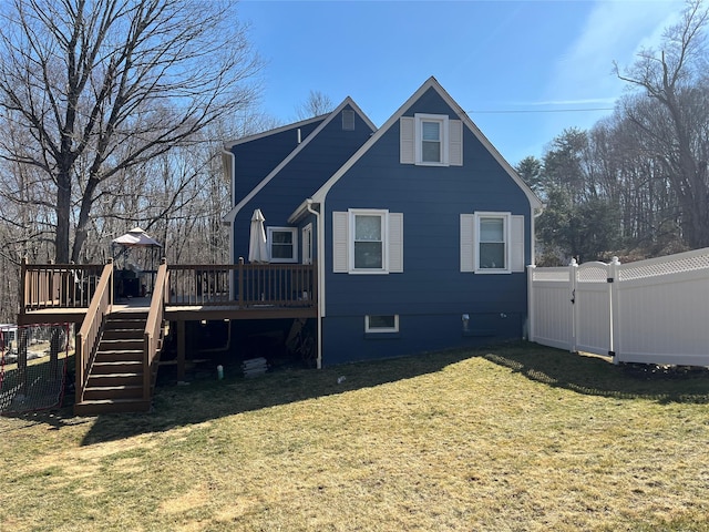 rear view of house with a lawn, a deck, a gate, fence, and stairs