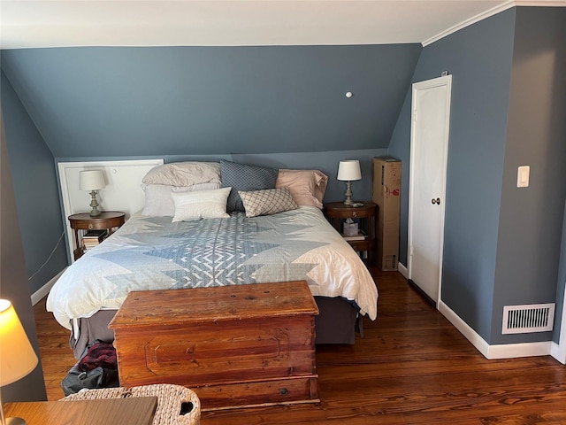 bedroom featuring vaulted ceiling, visible vents, baseboards, and wood finished floors