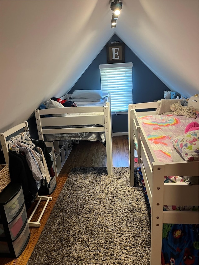 bedroom with vaulted ceiling and wood finished floors