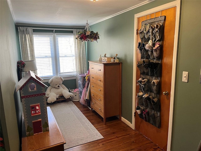 game room with dark wood finished floors, baseboards, and ornamental molding