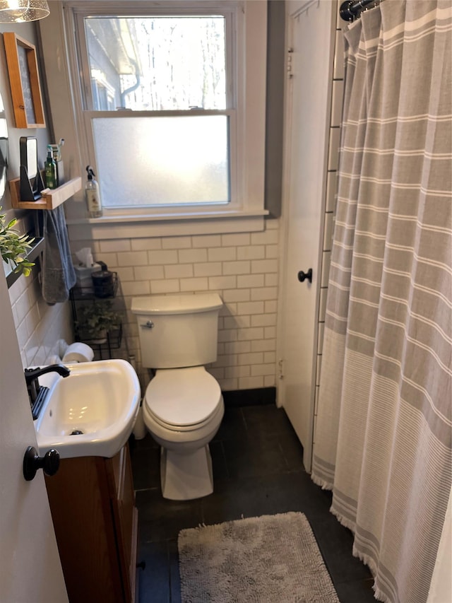 full bath featuring tile walls, a shower with shower curtain, toilet, and vanity