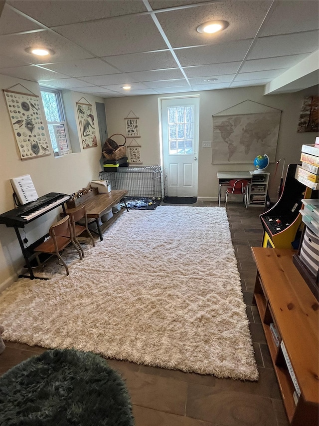 interior space with a drop ceiling and baseboards