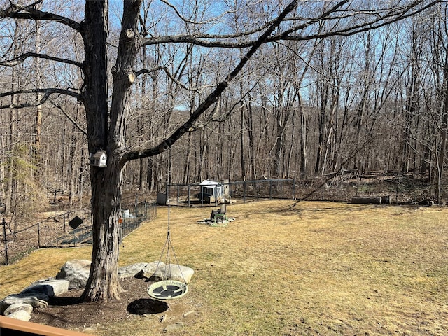 view of yard with fence and a wooded view