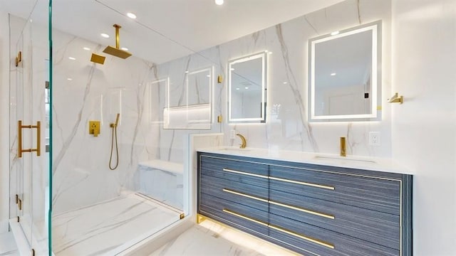 full bathroom with a marble finish shower, marble finish floor, double vanity, and a sink