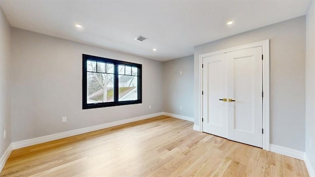 unfurnished bedroom featuring visible vents, baseboards, recessed lighting, a closet, and light wood-type flooring