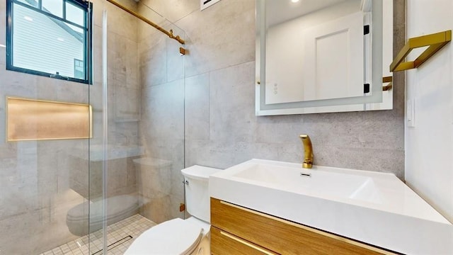 full bathroom featuring a shower stall, vanity, toilet, and tile walls