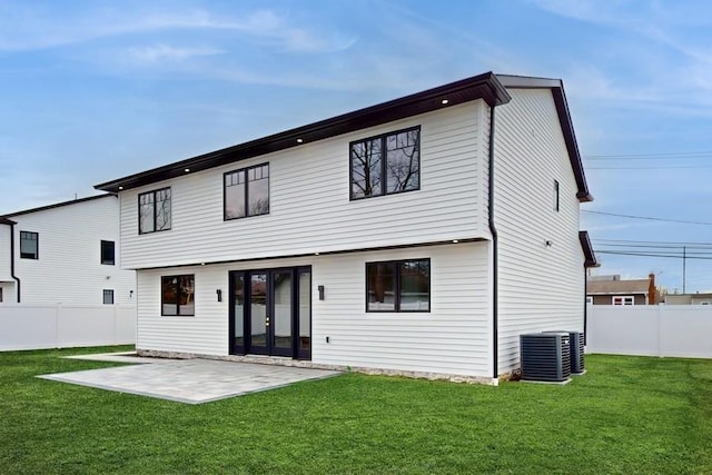 rear view of property featuring central AC unit, a yard, a patio area, and a fenced backyard