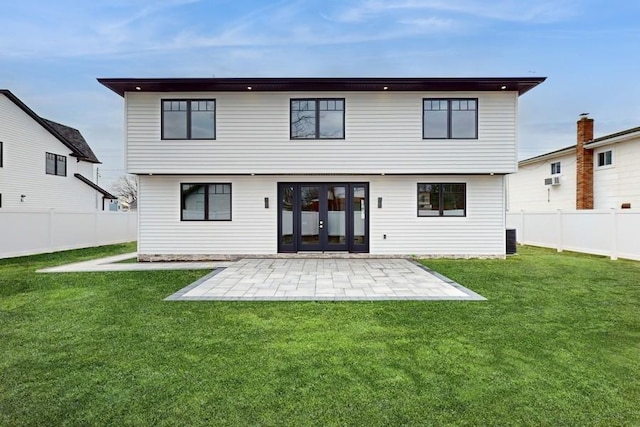 rear view of property featuring a patio, a yard, and a fenced backyard