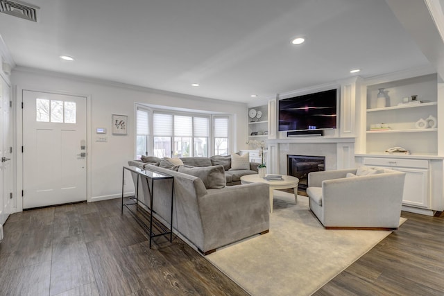 living area featuring visible vents, a healthy amount of sunlight, and dark wood-type flooring