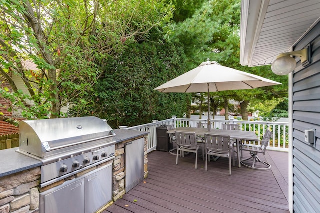 wooden terrace featuring area for grilling and outdoor dining area