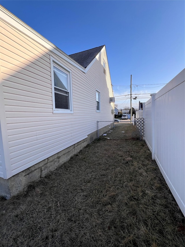 view of side of home featuring a yard and fence