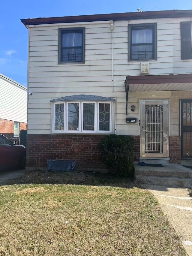 view of front of home featuring brick siding and a front yard