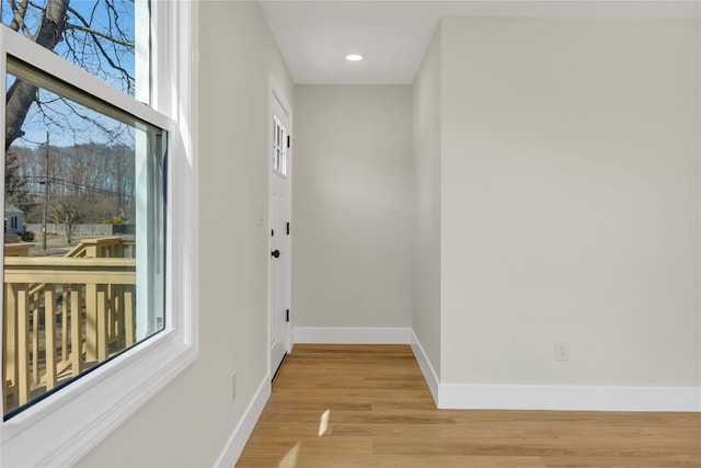 hall featuring recessed lighting, baseboards, and light wood-style flooring