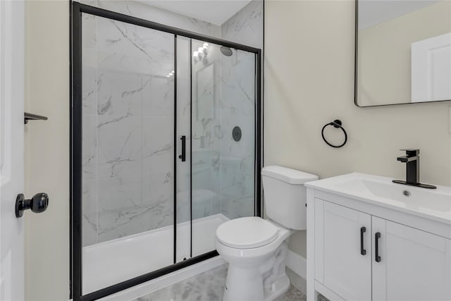 full bath with a marble finish shower, toilet, and vanity