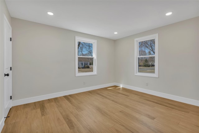 spare room featuring recessed lighting, light wood-type flooring, and baseboards