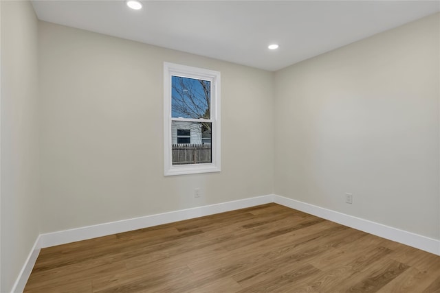 unfurnished room featuring recessed lighting, light wood-type flooring, and baseboards