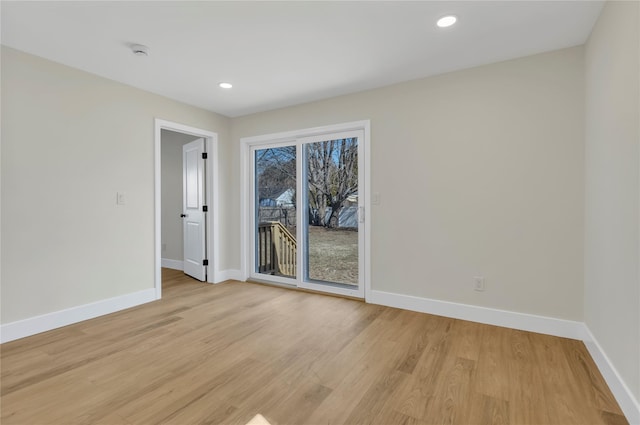 spare room featuring recessed lighting, light wood-style flooring, and baseboards