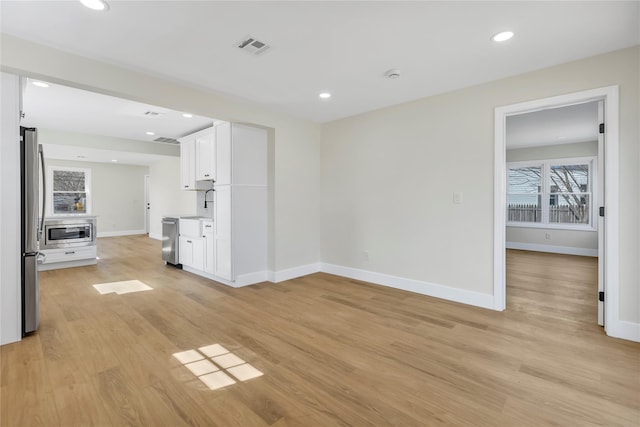 interior space featuring recessed lighting, light wood-style floors, and baseboards