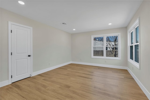 empty room featuring recessed lighting, baseboards, and light wood-style floors