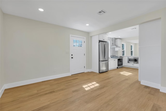 unfurnished living room with recessed lighting, baseboards, visible vents, and light wood finished floors