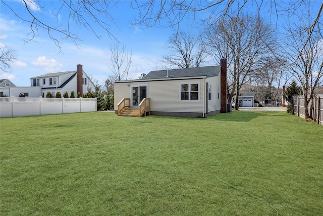 back of house featuring a lawn, entry steps, and fence