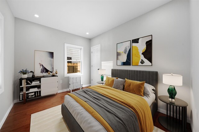 bedroom featuring recessed lighting, baseboards, radiator, and wood finished floors