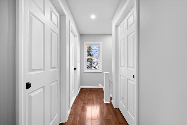 hallway with dark wood-type flooring, recessed lighting, and baseboards