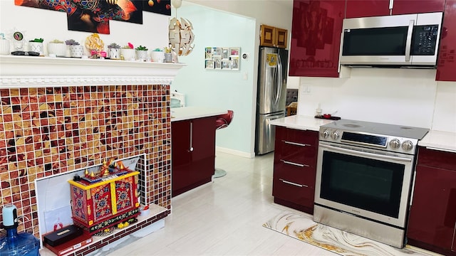 kitchen with stainless steel appliances, baseboards, and light countertops