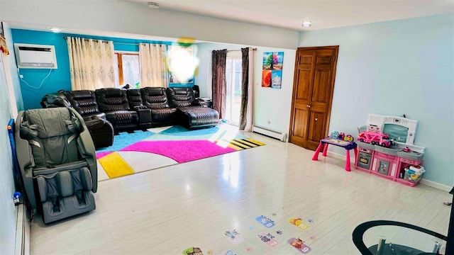 living area featuring wood finished floors, a wall unit AC, and a baseboard radiator