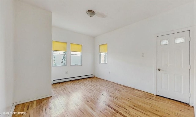 spare room with light wood-style floors and baseboard heating