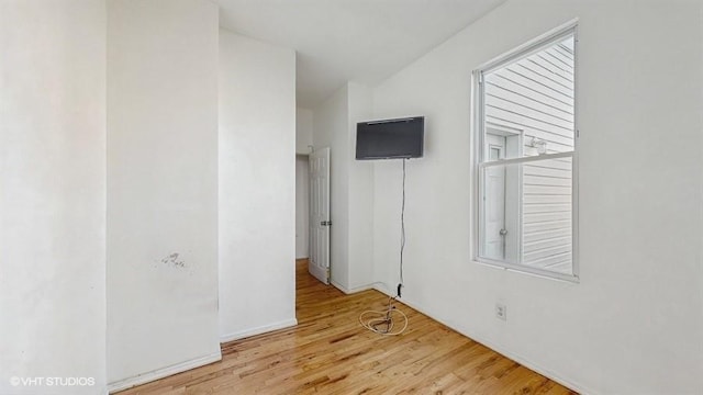 spare room featuring a wealth of natural light and wood finished floors